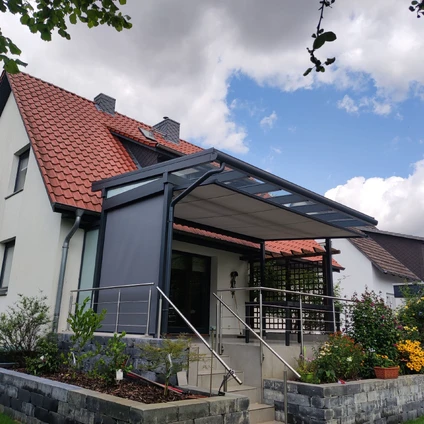 Modernes Haus mit rotem Dach und schräger überdachter Veranda über dem Eingangsbereich