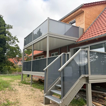 Modulare Außentreppe und Veranda mit Glasgeländern an einem Wohnhaus
