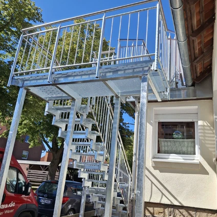Neue Metallbalkonkonstruktion mit Treppe und Geländer an die Fassade eines Hauses